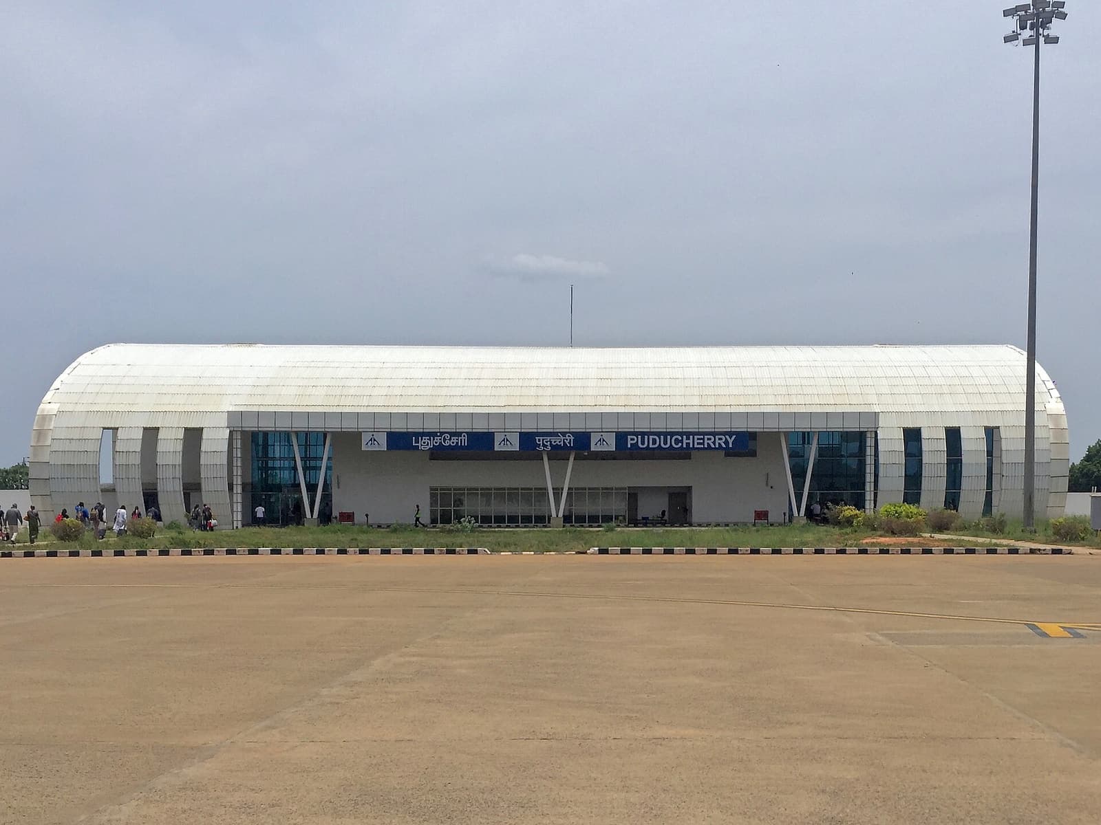 The white arched terminal building of Puducherry Airport seen from the apron