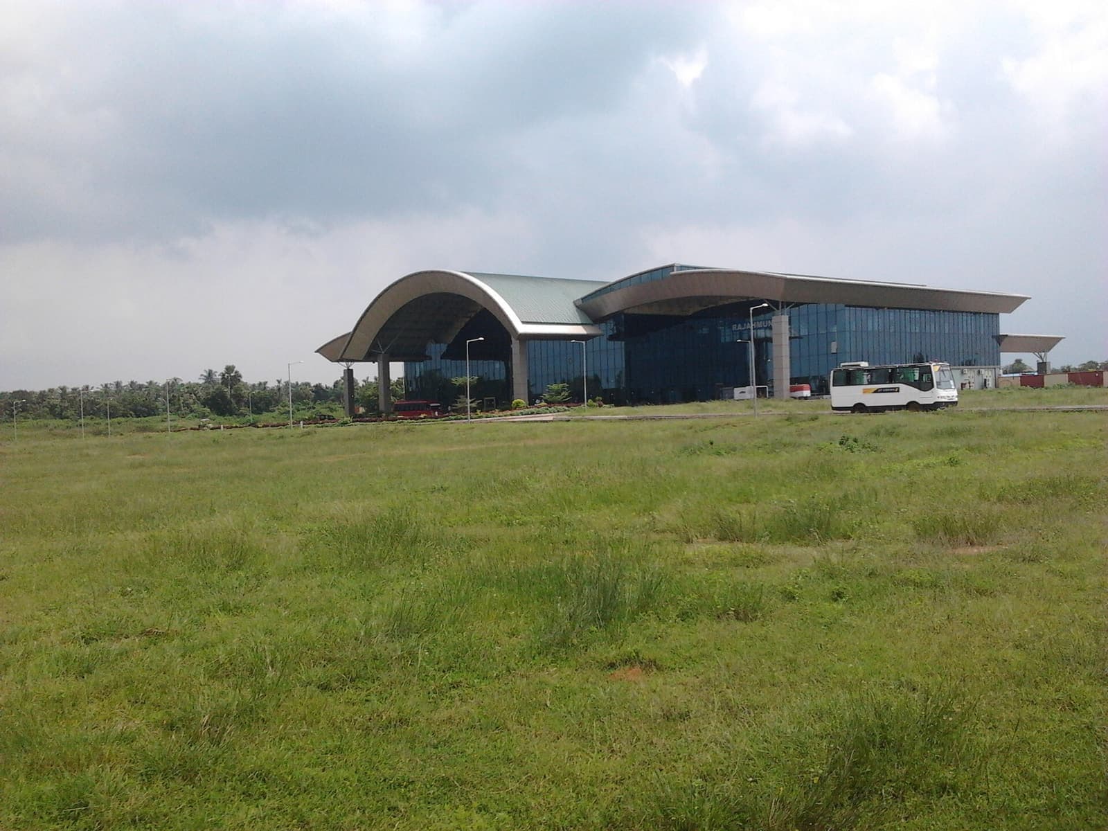 The terminal building of Rajahmundry Airport across a grass field