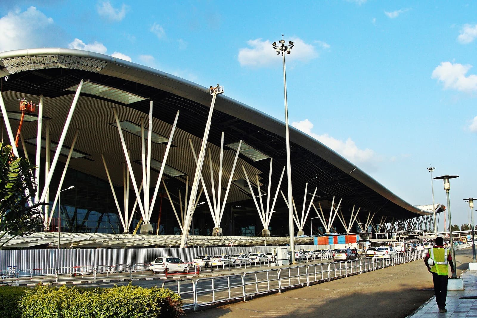 The kerbside of the terminal building at Kempegowda International Airport, Bengaluru, under a blue sky