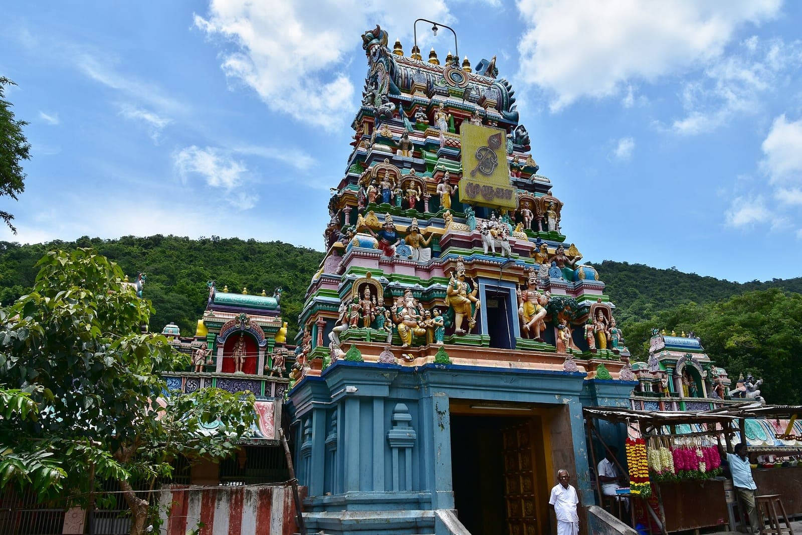 The colourful gopuram of the Kallalagar Temple at Alagar Kovil, with wooded hills behind