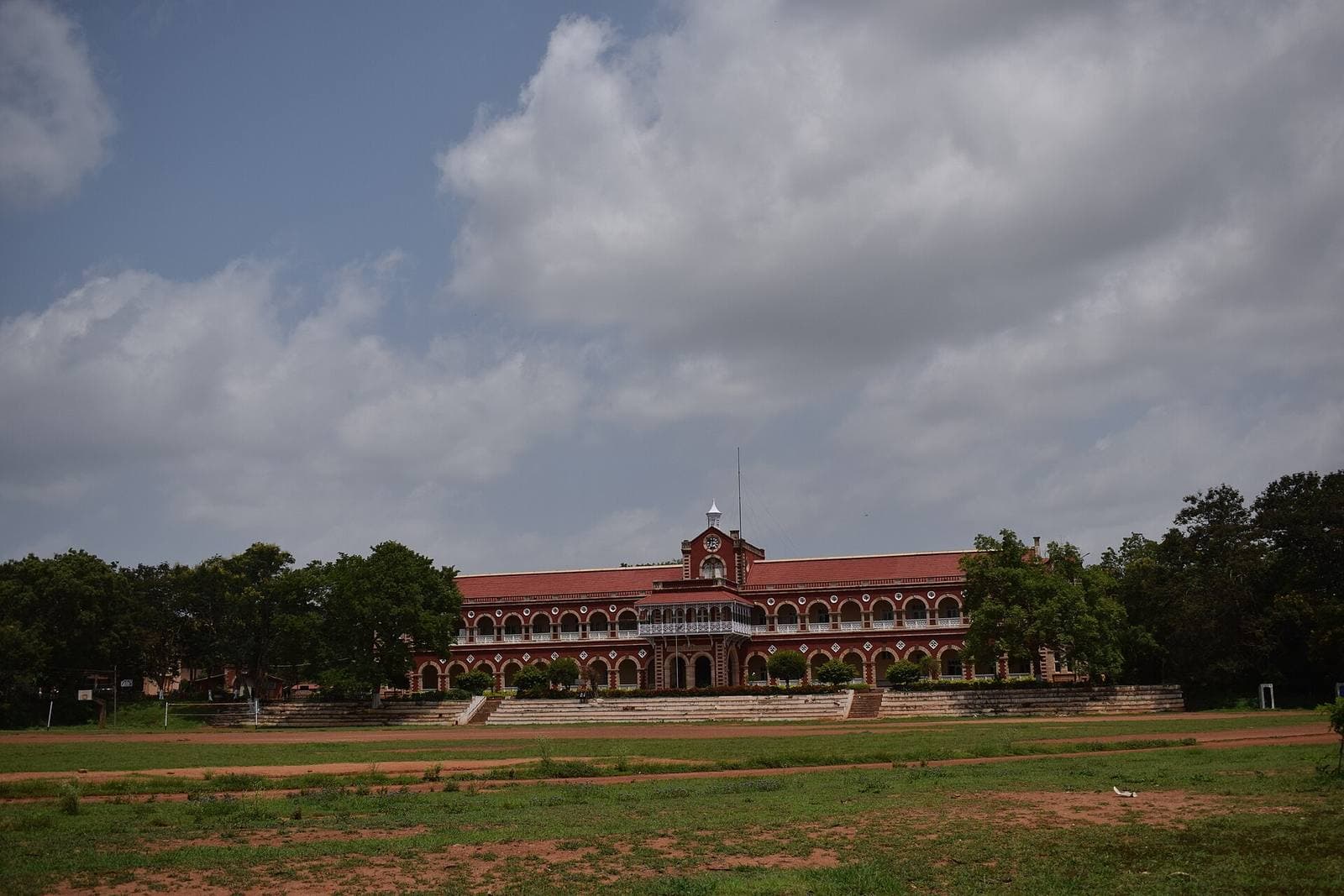 The Karnatak College building in Dharwad under a cloudy sky