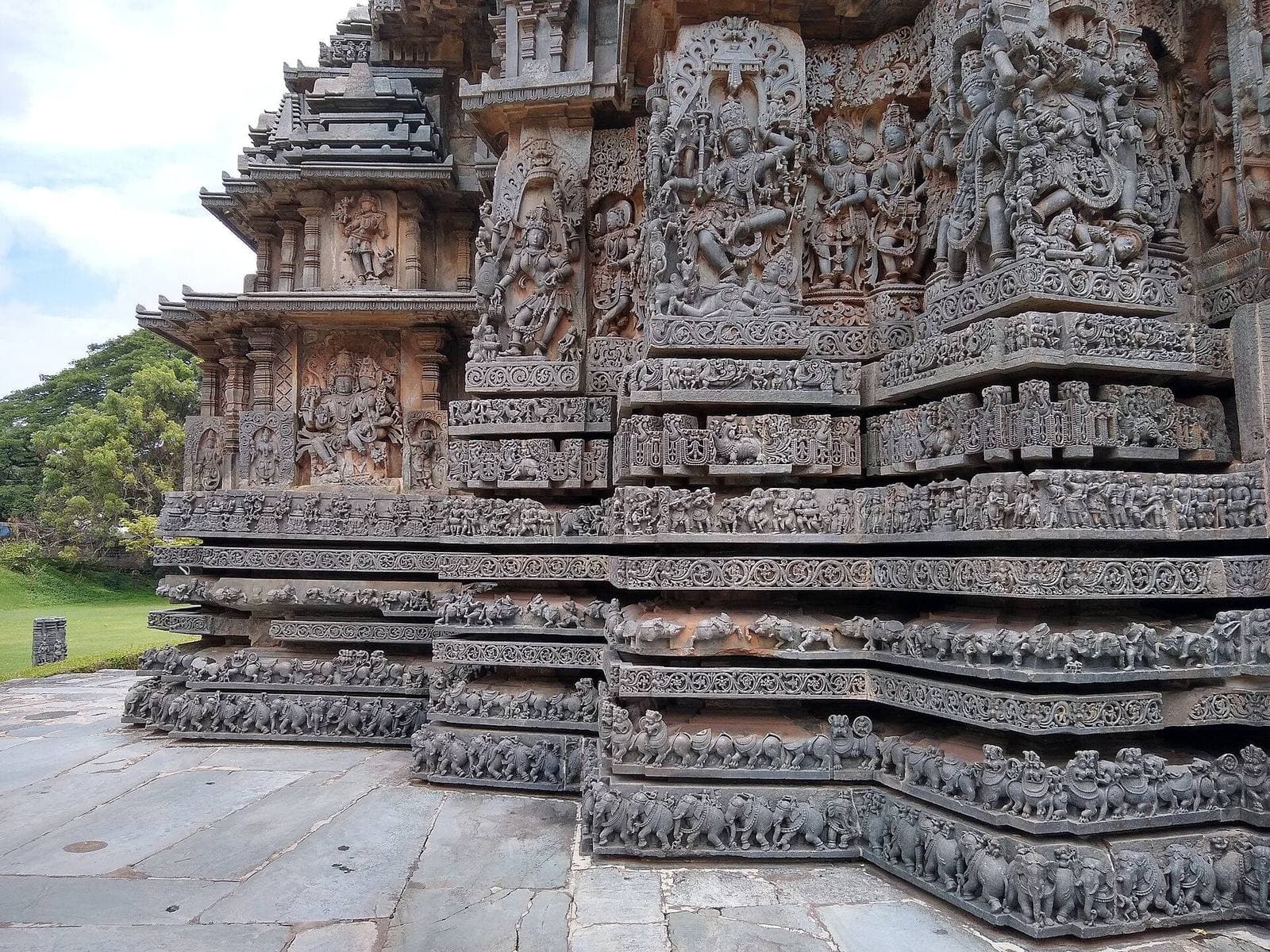 Intricate Hoysala stone carvings on a temple wall near Hassan