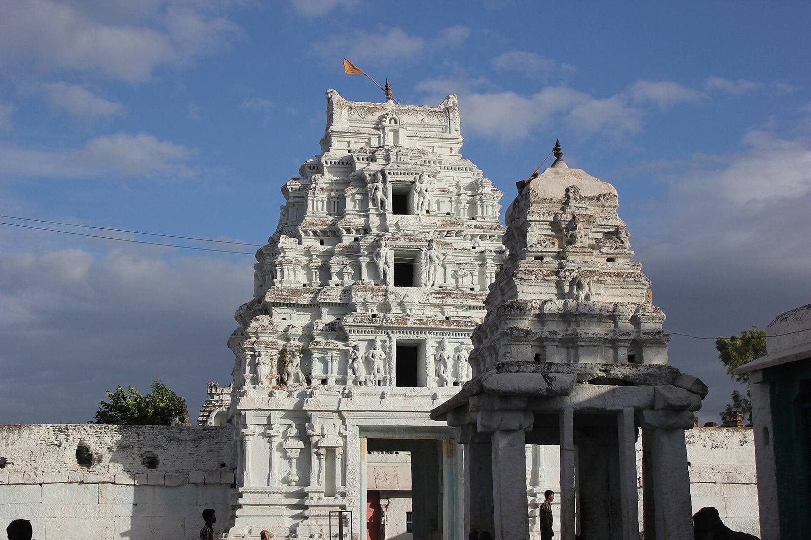 White temple towers in Hosapete under a cloudy sky