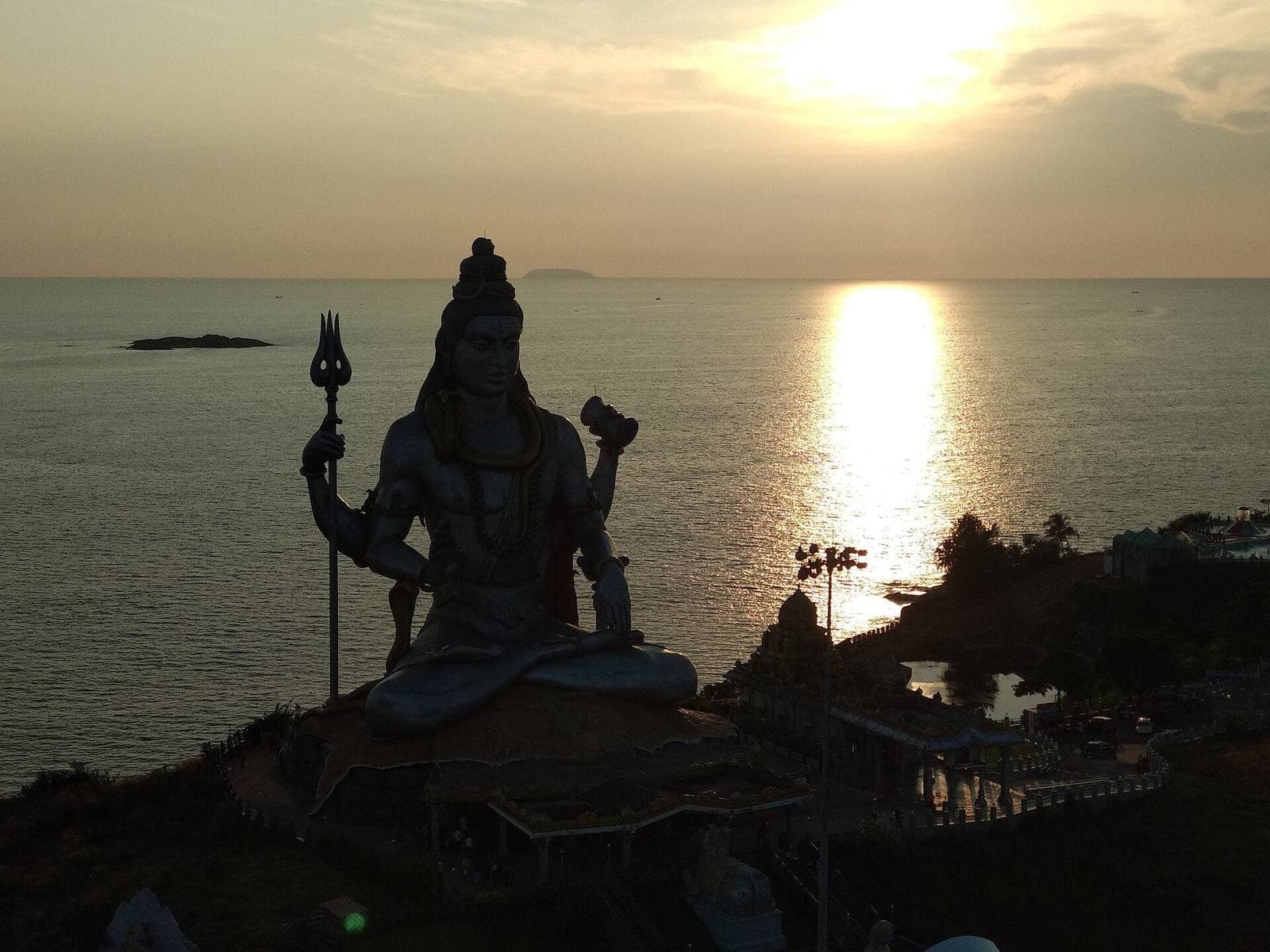 The giant Shiva statue at Murudeshwar silhouetted against the sea at sunset