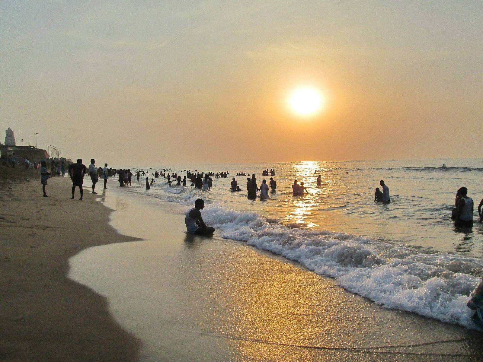 Bathers at sunrise on the beach at Tiruchendur