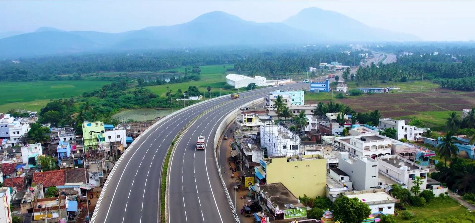 A highway through Visakhapatnam with hills in the distance