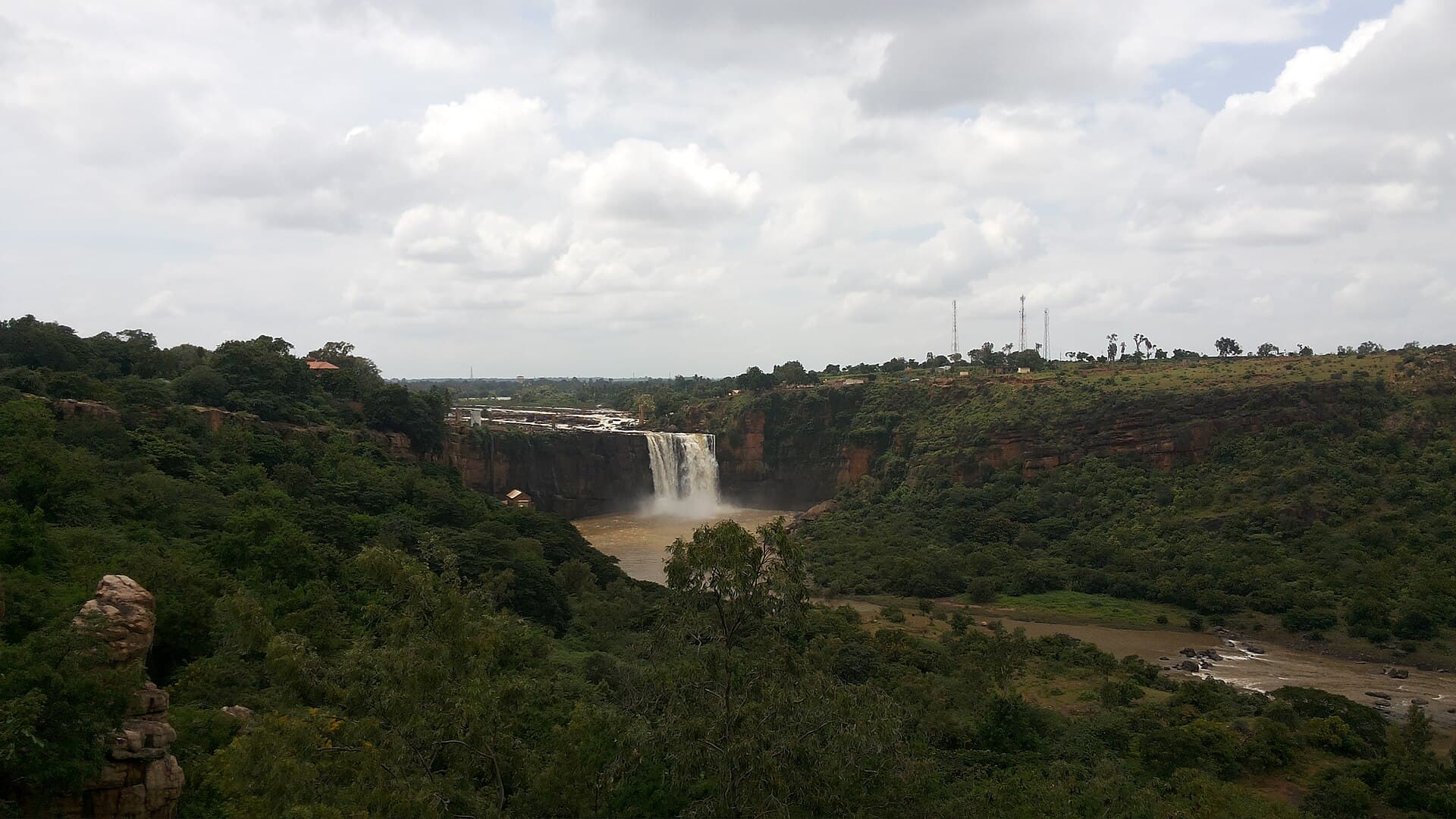 Gokak Falls dropping over a cliff into a wooded gorge in Belagavi district