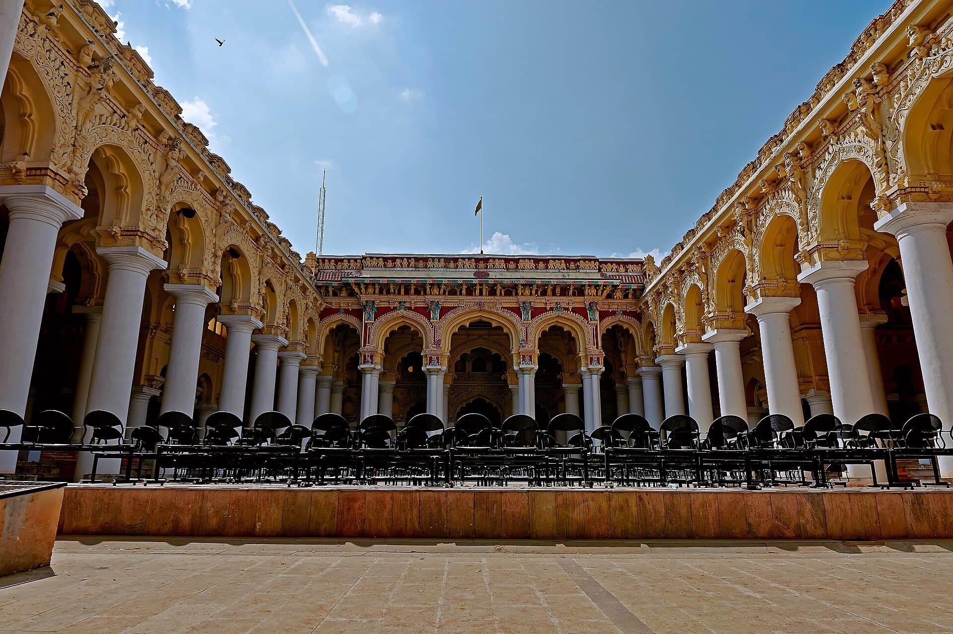 The arcaded courtyard of Thirumalai Nayakkar Mahal in Madurai, with white columns and carved arches