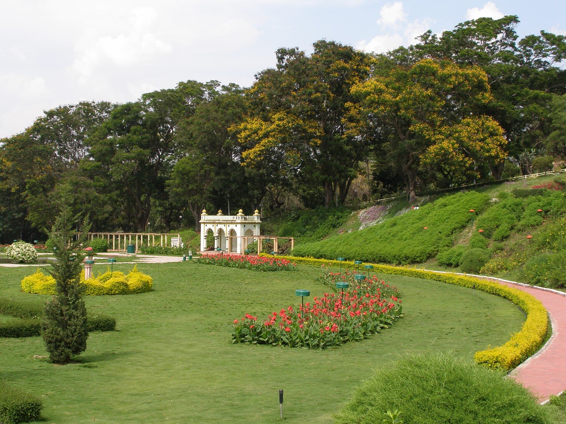 Lawns, flower beds and a small white pavilion at Brindavan Gardens near Mysuru