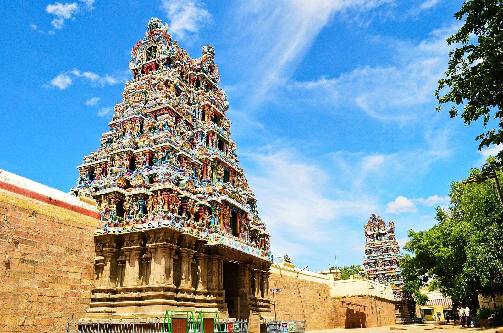 A colourful gopuram of the Meenakshi Amman Temple in Madurai against a blue sky